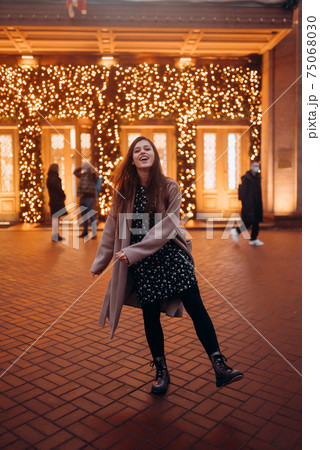 Girl on the background of the illuminated entrance to the building Girl on the background of the illuminated entrance to the building 75068030
