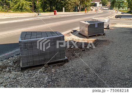 construction of brick paved sidewalk, piles of packed pave stones 75068218