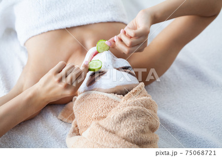 Skin care, woman with beautiful facial skin applying mask on face 75068721