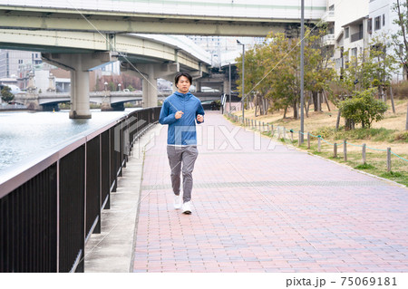 都心でジョギングしている男性 75069181