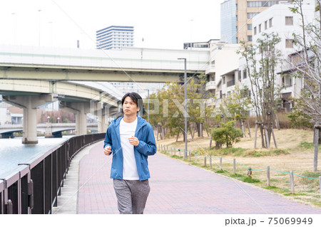 都心でジョギングしている男性 75069949