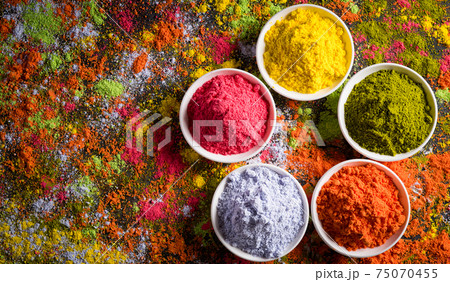 Holi festival celebration. Traditional Indian Holi colours powder decoration with paints. Top view of Organic Gulal colors in bowls ondark background. 75070455