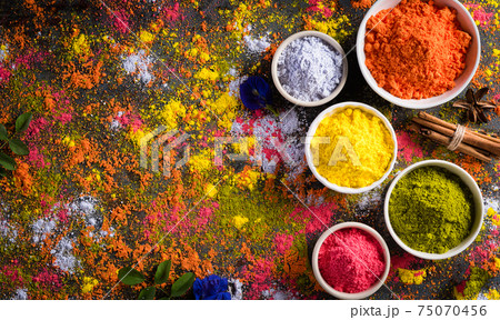 Holi festival celebration. Traditional Indian Holi colours powder decoration with paints. Top view of Organic Gulal colors in bowls ondark background. Holi festival celebration. Traditional Indian Holi colours powder decoration with paints. Top view of Organic Gulal colors in bowls ondark background. 75070456