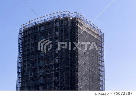 大規模修繕工事中の足場を組んだマンション 75072287