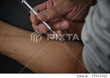 注射器で注射をする人 75072362