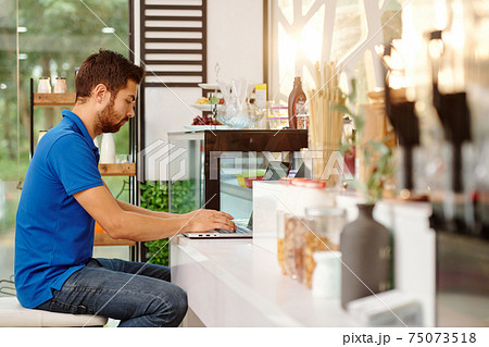 Coffeeshop owner working on laptop 75073518