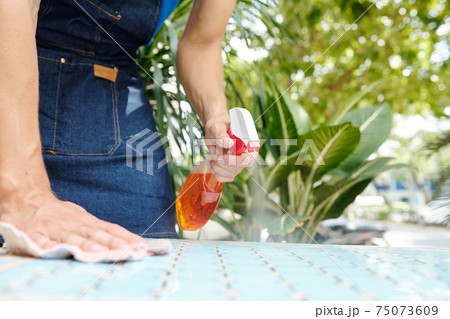 Spraying detergent on cafe table 75073609