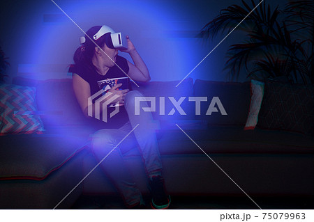 Woman watching movie at home using vr headset Woman watching movie at home using vr headset 75079963