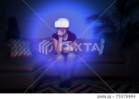 Woman watching movie at home using vr headset Woman watching movie at home using vr headset 75079964