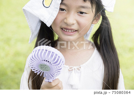 汗をかいてハンディー扇風機で涼む小学生女の子 汗をかいてハンディー扇風機で涼む小学生女の子 75080364