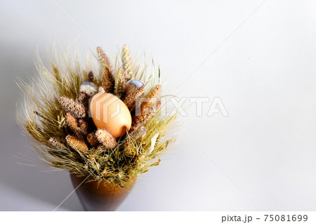 Easter eggs in a nest of dried flowers. On a gray background. Easter eggs in a nest of dried flowers. On a gray background. 75081699
