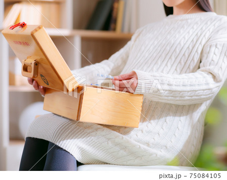 薬箱から薬を取り出す妊婦　4:3 75084105