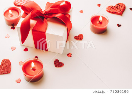 Valentine day composition: red love hearts, romantic gift box, candle on white background. February romance present card. 75086196