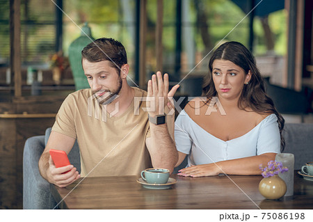 Bored woman and busy man with smartphone 75086198