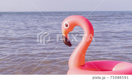 Hello summer. Pink inflatable flamingo in blue ocean water for sea summer beach background. Trendy summer concept. 75086591
