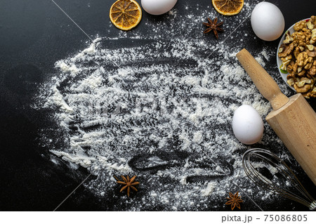 Bakery composition. Cooking food ingredients: flour, eggs, nut and star anise, orange on dark table kitchen background for cake. Top View Copy Space. Cookies Pie Or Cake Recipe Mockup. 75086805