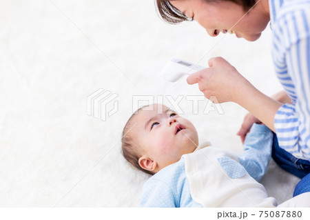 赤ちゃんの体温を測る母親 75087880