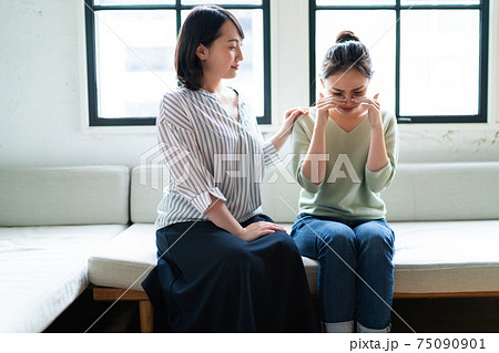 落ち込む友達を励ます女性の写真素材