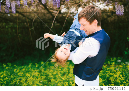 Father is having fun with his son in the park on a sunny day Father is having fun with his son in the park on a sunny day 75091112