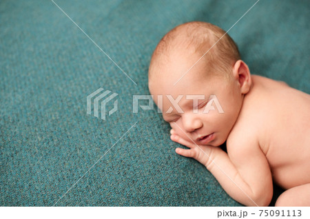 2. Portrait of a newborn sleeping with his hands under his cheeks on a turquoise background. 2. Portrait of a newborn sleeping with his hands under his cheeks on a turquoise background. 75091113
