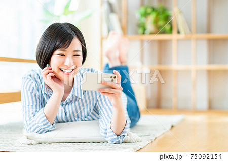 スマホで動画を見る若い女性 75092154