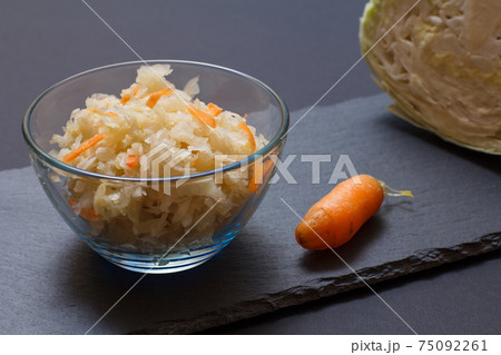Fermented cabbage with herbs and spices in glass bowl on the black background Fermented cabbage with herbs and spices in glass bowl on the black background 75092261