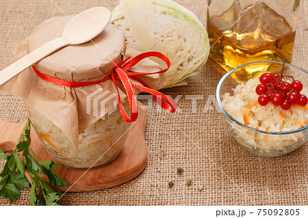 Fermented cabbage with herbs and spices in glass bowl and jar on the sackcloth Fermented cabbage with herbs and spices in glass bowl and jar on the sackcloth 75092805