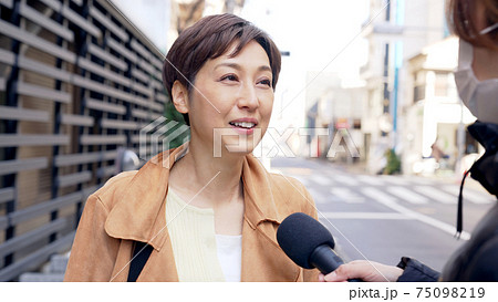 街頭インタビューを受ける女性 75098219