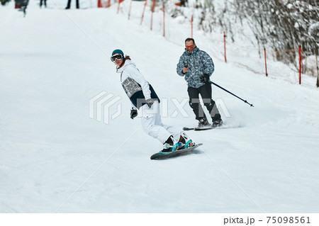 Downhill skier. Snowboarders and skier ride on snow in the mountains. Downhill ride. Adventure skiers season. Skiing and Snowboarding Resorts. Ski and snowboard equipment. Snow sports enthusiasts Downhill skier. Snowboarders and skier ride on snow in the mountains. Downhill ride. Adventure skiers season. Skiing and Snowboarding Resorts. Ski and snowboard equipment. Snow sports enthusiasts 75098561