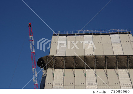 マンション工事の現場 巨大クレーンと防音シートの写真素材 マンション工事の現場 巨大クレーンと防音シートの写真素材