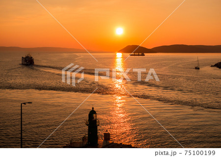 Sunset over the Adriatic Sea and its boats playing in the reflections at the entrance to the port of Split in Croatia Sunset over the Adriatic Sea and its boats playing in the reflections at the entrance to the port of Split in Croatia 75100199
