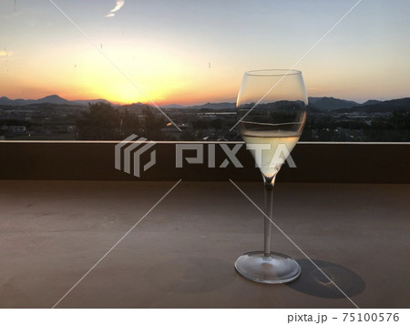 夕焼けの見えるお洒落なBARでシャンパンを飲む 75100576