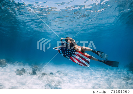 Freediver woman swim over sandy sea with United States flag. 75101569
