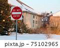 Do not enter sign on the residential building background, entry is prohibited. Winter, snowfall in North American suburban. Icey, snowy street 75102965