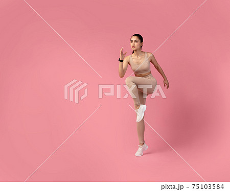 Young Woman Doing High Knees Exercise Isolated On Pink Background Young Woman Doing High Knees Exercise Isolated On Pink Background 75103584