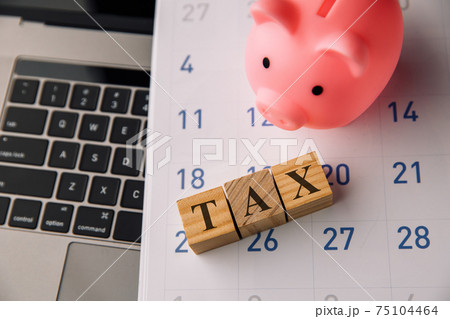 Wooden blocks with the word TAX and piggy bank. Tax planning, tax refund or Tax concept. Wooden blocks with the word TAX and piggy bank. Tax planning, tax refund or Tax concept. 75104464