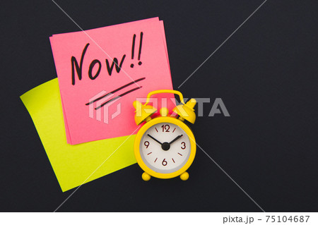 Sticker with handwriting the word NOW on alarm clock on dark blue background with copy space using as stop procrastination, self discipline or motivation to complete task 75104687