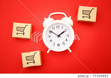 Delievery box and white alarm clock on red background. Express delivery concept. Temporary storage, limited offer and discount. Optimization of logistics and delivery, improving transportation Delievery box and white alarm clock on red background. Express delivery concept. Temporary storage, limited offer and discount. Optimization of logistics and delivery, improving transportation 75104691