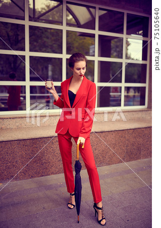 Businesswoman walking near office, girl walk with umbrella while it is raining outdoors, female manager near modern bank building Businesswoman walking near office, girl walk with umbrella while it is raining outdoors, female manager near modern bank building 75105640