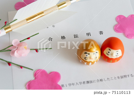 入試の合格証書とダルマ、合格祈願の破魔矢、桜の花びら 75110113
