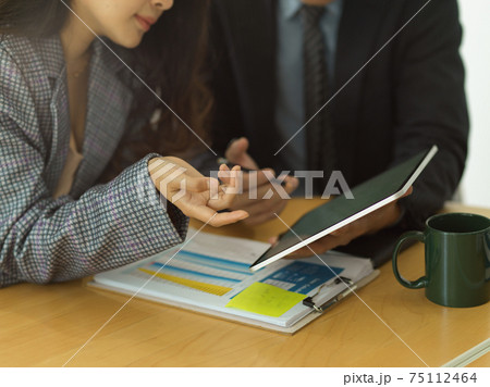 Two businesspeople brainstorming on their project with digital tableland business paperwork 75112464