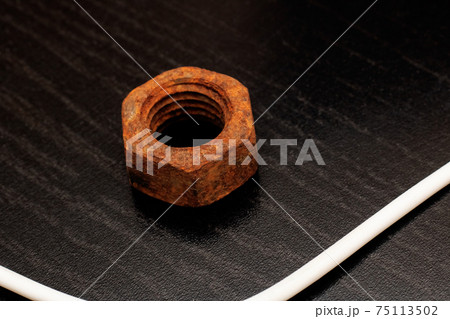 Large old rusty nut close up on black background 75113502
