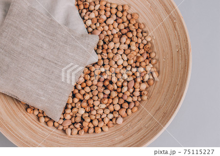 Cherry stone pillows in a bowl with cherry stones, cherry pit filled pillow for spa massage - natural heat or cool pack. Alternative medicine and therapy, pit sack for chiropractic care. Mockup image 75115227