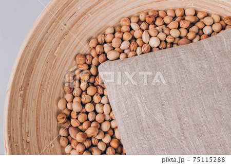 Cherry stone pillow in a bowl with cherry stones, cherry pit filled pillow for spa massage - natural heat or cool pack. Alternative medicine and therapy, pit sack for chiropractic care. Mockup image 75115288