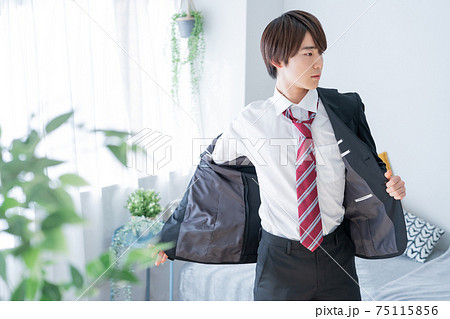 朝出勤のためスーツを着る若い男性 朝出勤のためスーツを着る若い男性 75115856