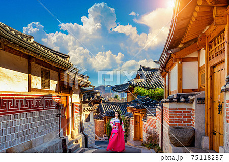 Beautiful girl wearing Korean traditional hanbok at Bukchon Hanok Village. Traditional Korean style architecture in Seoul,Korea. Beautiful girl wearing Korean traditional hanbok at Bukchon Hanok Village. Traditional Korean style architecture in Seoul,Korea. 75118237