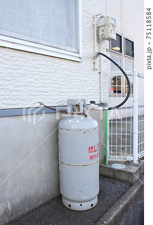 屋外の壁面に設置されたLPガスボンベ 75118584