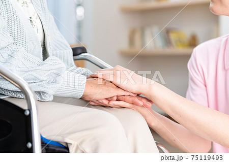 寄り添う若いヘルパーとシニア女性 75119493