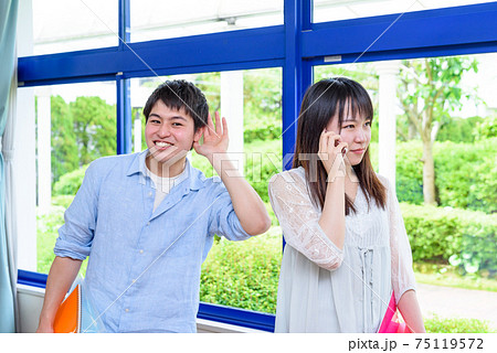 大学の講義室で電話する大学生と盗み聞き　情報管理、情報漏洩イメージ 75119572