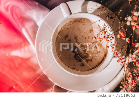 White cup of milk and chocolate. Morning aesthetics vibes. Breakfast. Pink gypsophila flowers 75119652